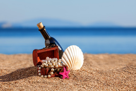 Decorative chest with jewelry,bottle and starfish on a beachの写真素材
