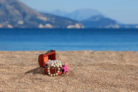 Decorative chest with jewelry and starfish on a beachの写真素材
