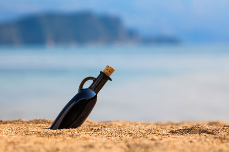 Black bottle on a beachの写真素材