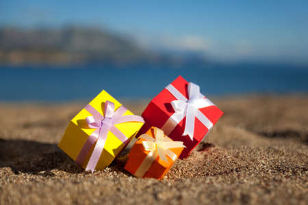 Group of multicolored gift boxes on a beachの写真素材