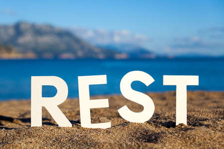 White paper figurines of letters on a sandbeachの写真素材