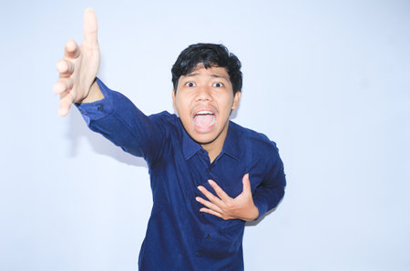 heart attacked asian man office worker screaming and touch his chest with gesture reaching out for help suffering from heart pain, wear navy shirtの写真素材