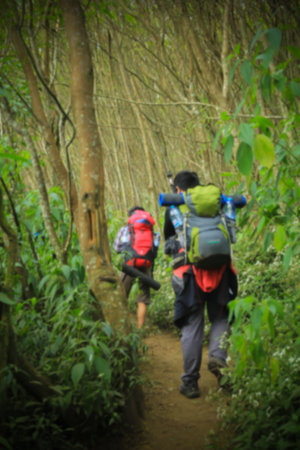 blurred of two man hiking in the arjuno mountain trekking route carrying carrier
