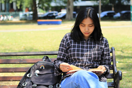 young woman asian student read a note book seriously to prepare examinationの写真素材
