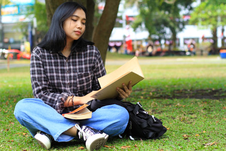 young woman asian student read a note book seriously to prepare examinationの写真素材