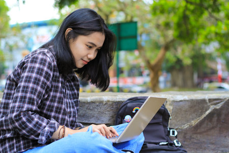 relax asian young woman smiling using laptop working freelance and happy get e commerce offerの写真素材