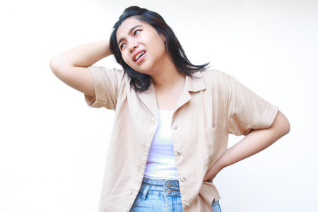 confused asian woman hold her head feels stressed and overwhelmed wearing casual clothes isolated on white backgroundの写真素材