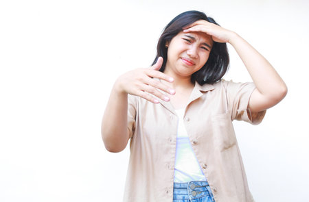 confused asian woman hold her head feels stressed and overwhelmed wearing casual clothes isolated on white backgroundの写真素材