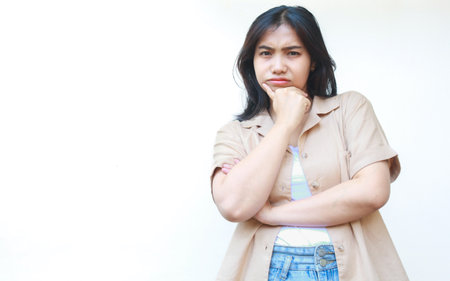 thoughtful asian woman thinking seriously wearing casual brown clothes isolated on white backgroundの写真素材