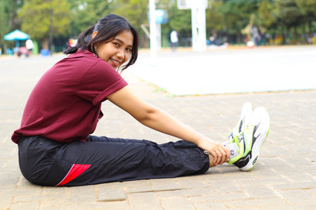 happy asian woman doing yoga in outdoors volleyball courtの写真素材