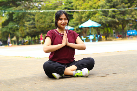 happy asian woman doing yoga in outdoors volleyball courtの写真素材