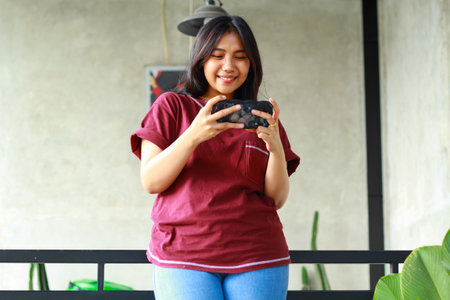 happy asian woman using smartphone to playing mobile game sitting in cafe