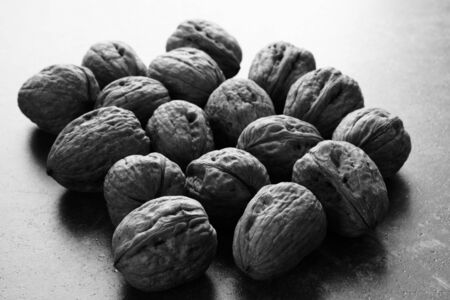 a group of walnuts on the table photographed in black and whiteの写真素材