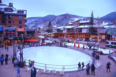 Vail, Colorado/USA-December, 30,2018. Small town at the base of Vail Mountain, gateway for winter sports. People walking on busy streets next to skating rink. Stores and  mountains in the background.のeditorial素材