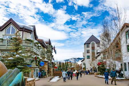 Vail, Colorado/USA-December, 30,2018. Vail village, small town at base of Vail Mountain, gateway for winter sports. People walking next to stores and restarants, mountains in background.のeditorial素材