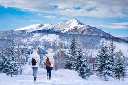 Friends hiking in the muntains. Girls enjoying beautiful Colorado mountain town on  winter break. Snowcapped mountains and houses. Silverthorne, Colorado, USA.の写真素材