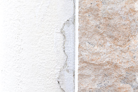 Cracked concrete wall. Uneven stucco surface backdrop. Unfinished work construction.の写真素材