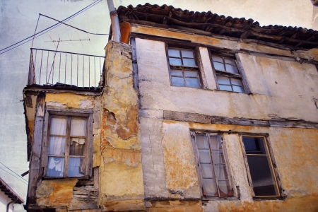 Part of the old ruined house with broken windows and damaged walls, after the natural disasterの写真素材