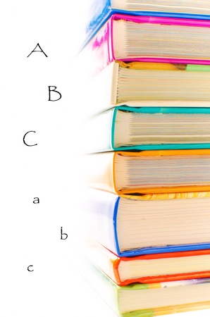 Forefront of a group of books stacked, with letters on white backgroundの写真素材