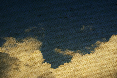 Sky and clouds on a textured, vintage paper background with grunge stains 