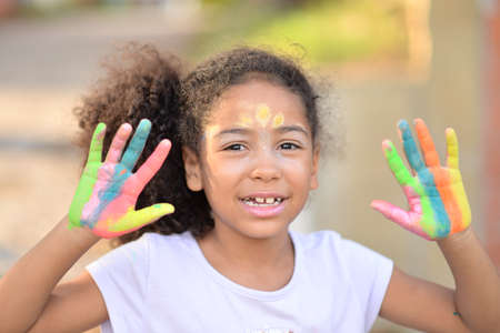 Portrait of a cute cheerful girl with painted hands, happiness of creation conceptの写真素材