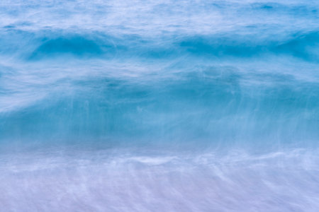 Abstract background of blue sea water with white foam, long exposure.の写真素材