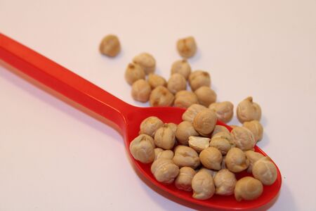 uncooked white chickpeas on spoon in kitchen white chickpeas are important food ingredientの写真素材
