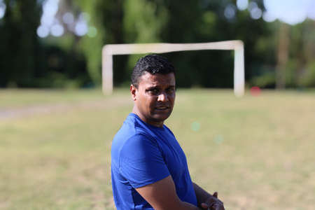 young man standing in front of football goal post in playgroundの写真素材