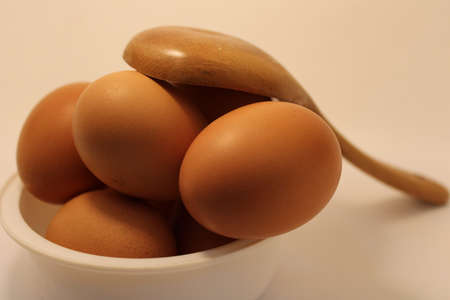 eggs on wooden spoon in kitchenの写真素材