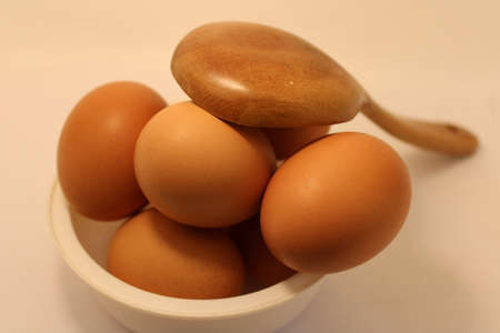 eggs on wooden spoon in kitchenの写真素材