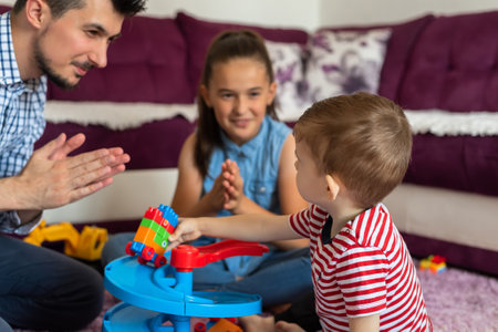 Happy family a young father with children playing together with toys on the floor in the living room.の写真素材