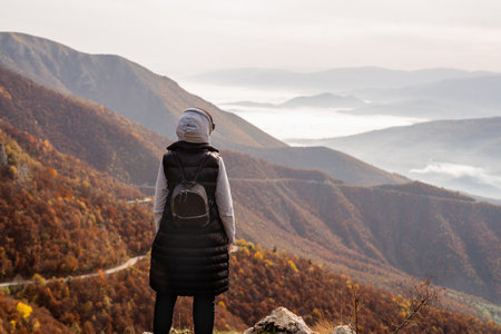 A woman who hikers enjoys a break look at the top of the mountain adventure travel.