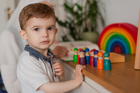 Teacher and preschool child playing together with colorful toys in the Montessori school classroom.の写真素材