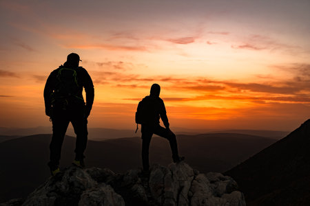 A two travelers who hikers enjoys a break look at the top of the rocky mountain during the hike. Adventure travelの写真素材