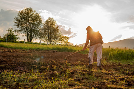 Farmer working on an agricultural fields in spring.