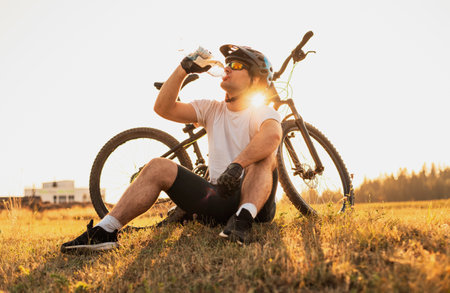 A professional mountain bike cyclist drinking water from the bottle active healthy lifestyle.の写真素材