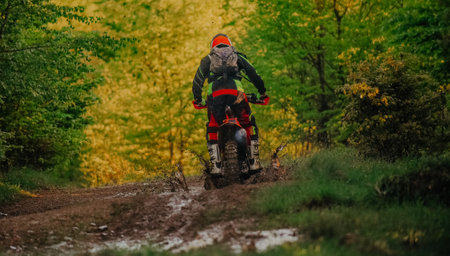 Professional enduro bike rider on action, dirt ride on the muddy road. Motocross sport.