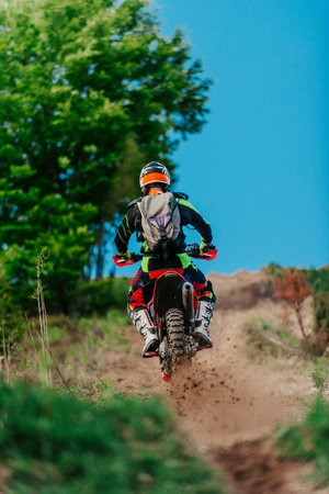 Professional enduro bike rider on action, dirt ride on the muddy road. Motocross sport.の写真素材