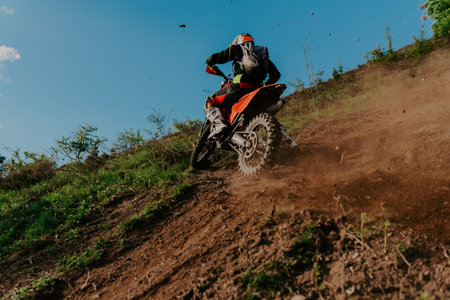 Professional enduro bike rider on action, dirt ride on the muddy road. Motocross sport.の写真素材