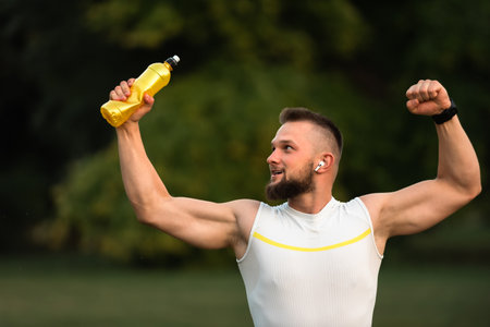 A young happy fit man raising his fist up after a successful workout. Concept of sports triumph, victory.の写真素材