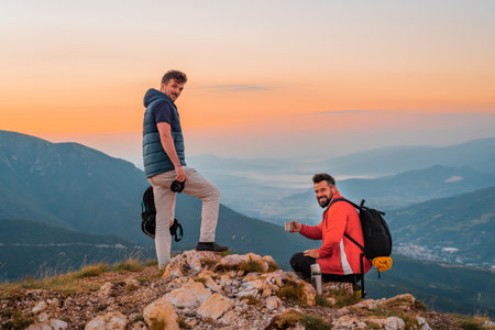 Two friends travelers enjoys a break at top of the mountain during the hike adventure travel.の写真素材