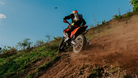 Professional enduro bike rider on action, dirt ride on the muddy road. Motocross sport.の写真素材