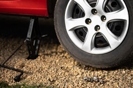 Unscrewed wheel on a car standing on a jack. Wheel repair or replacement of winter and summer tires.の写真素材
