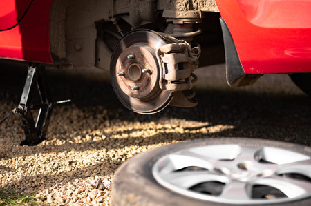 The rear hub of a car without a wheel with sun glare. Removed wheel in the foreground. The concept...