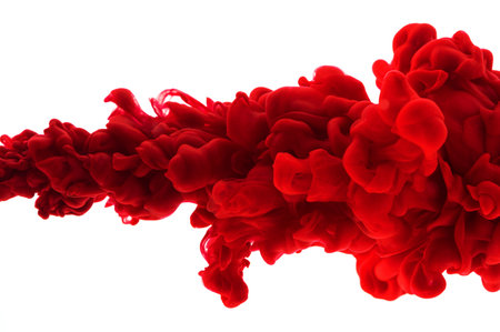 Red acrylic ink in water on white isolated background frozen motion very close up. Abstract...