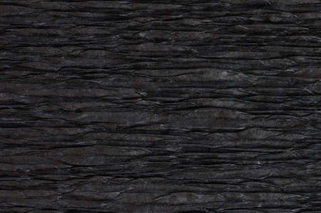 Background of black pressed corrugated paper with a horizontal texture taken close upの写真素材