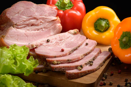 smoked meat is cut on a wooden table with the addition of fresh herbs, aromatic spices and paprika. A natural product from an organic farm produced using traditional methods. Rustic style close upの写真素材