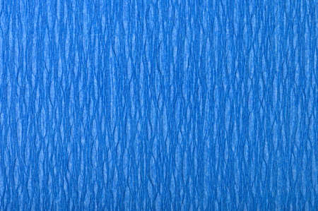 Background of blue pressed corrugated paper with vertical texture taken close up