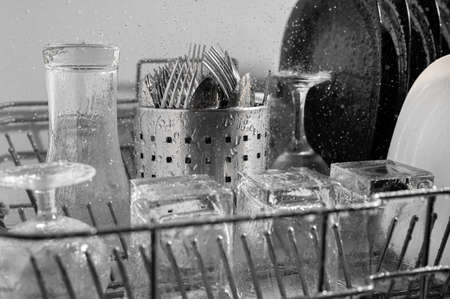dishes and cutlery in the dishwasher tray in a splash of water. Washing dishes with a dishwasher.の写真素材