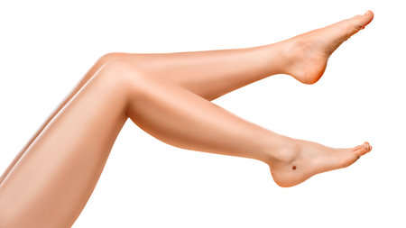 Beautiful well-groomed women's legs close-up on a white isolated background, The concept of epilation of foot skin care or getting rid of cellulite.の写真素材